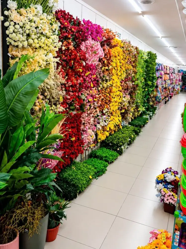 Corredor com parede de flores artificiais de uma loja Brasil Home
